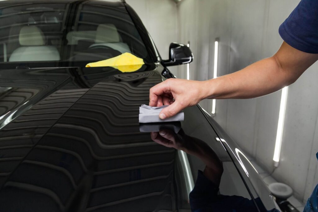 man polishing hood of a black truck