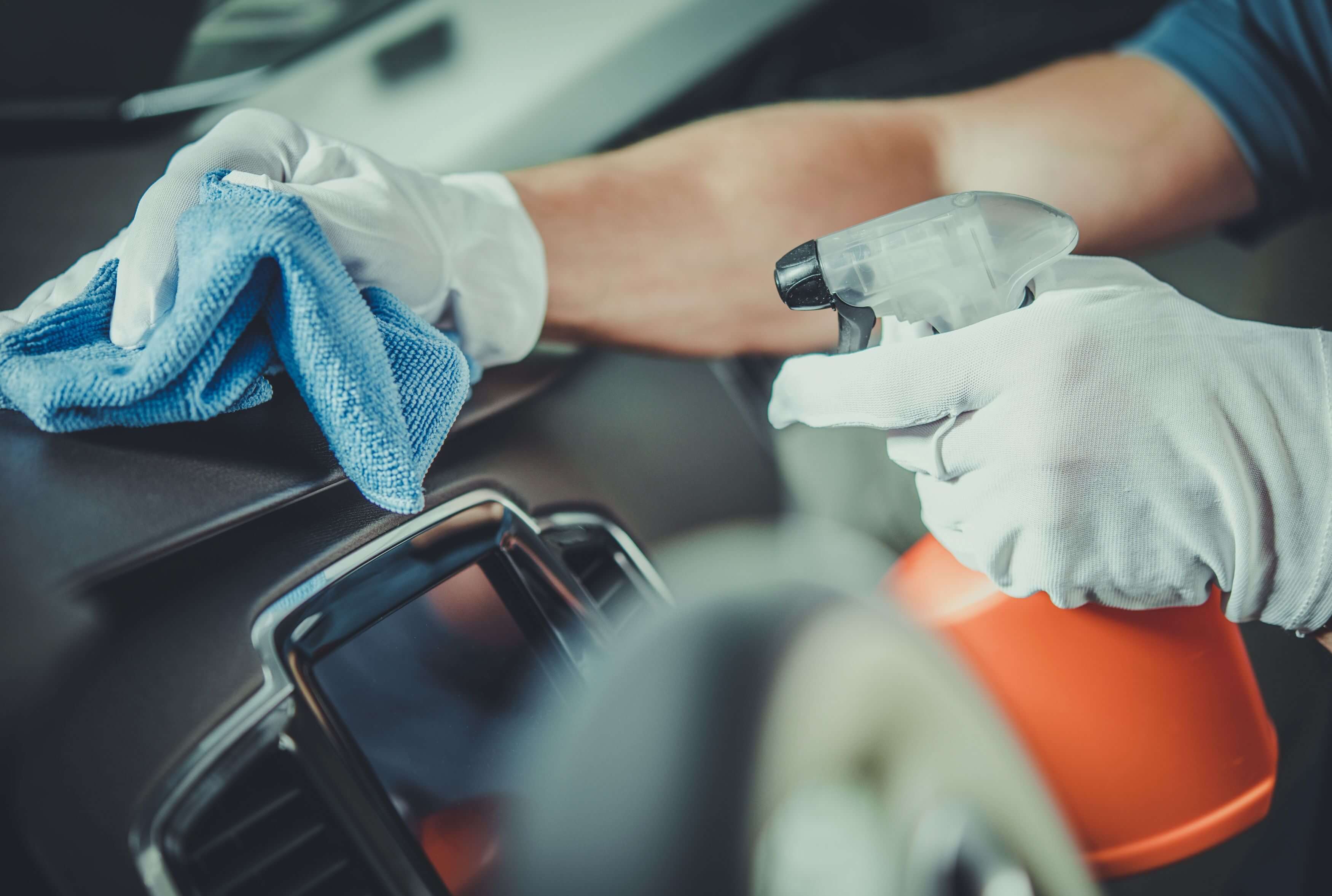 Man spraying car dash with cleaning solution