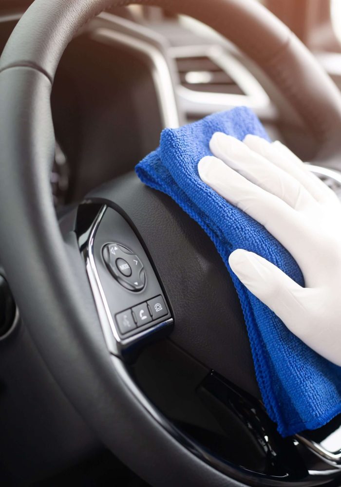 Detailer cleaning steering wheel
