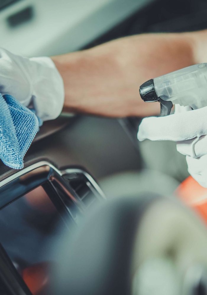 Man spraying car dash with cleaning solution